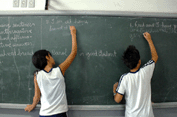 Alunos fazem tarefa no quadro negro na escola que é conhecida por ser exigente (Foto: João Bittar)